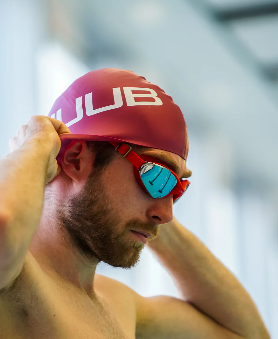 Bright orange HUUB silicone swim cap with a smooth, flexible design suitable for competitive and recreational swimming.